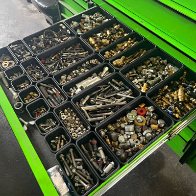 Boites-à-outils-dans-tiroirs-verts--atelier-remplies-vis-clous