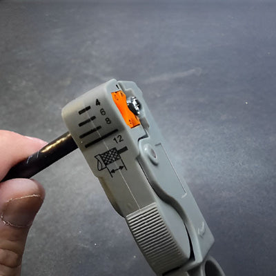 Gros cable bois introduit dans pince fond gris