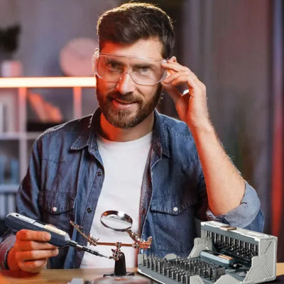 Homme-barbu-tient-lunette-travaille-tournevis-loupe-boitier-ouvert