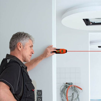 Homme tenant niveau laser arrête mur faisceau rouge horizontal