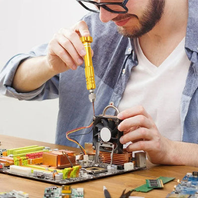 Jeune homme barbu lunette carrée circuit électroniques utilise tournevis jaune