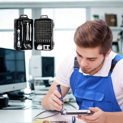 Jeune homme salopette bleue utilise tournevis tablette modèle noir