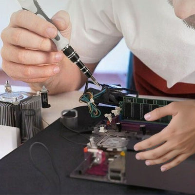 Tournevis dans main circuit électronique bureau noir chemise blanche