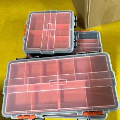 Trois boites à outils posees les unes sur les autres par terre