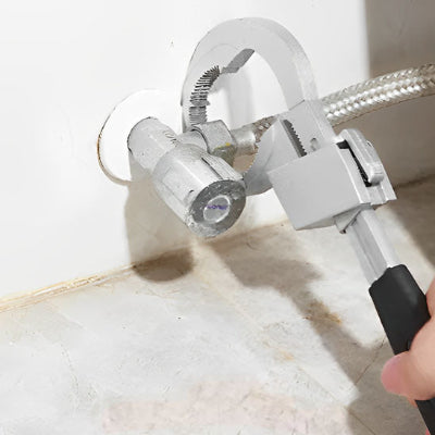 pince sur fin tuyau en bas de mur blanc